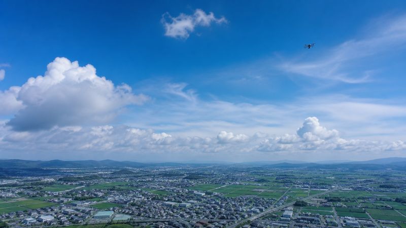 広い空を飛ぶドローン