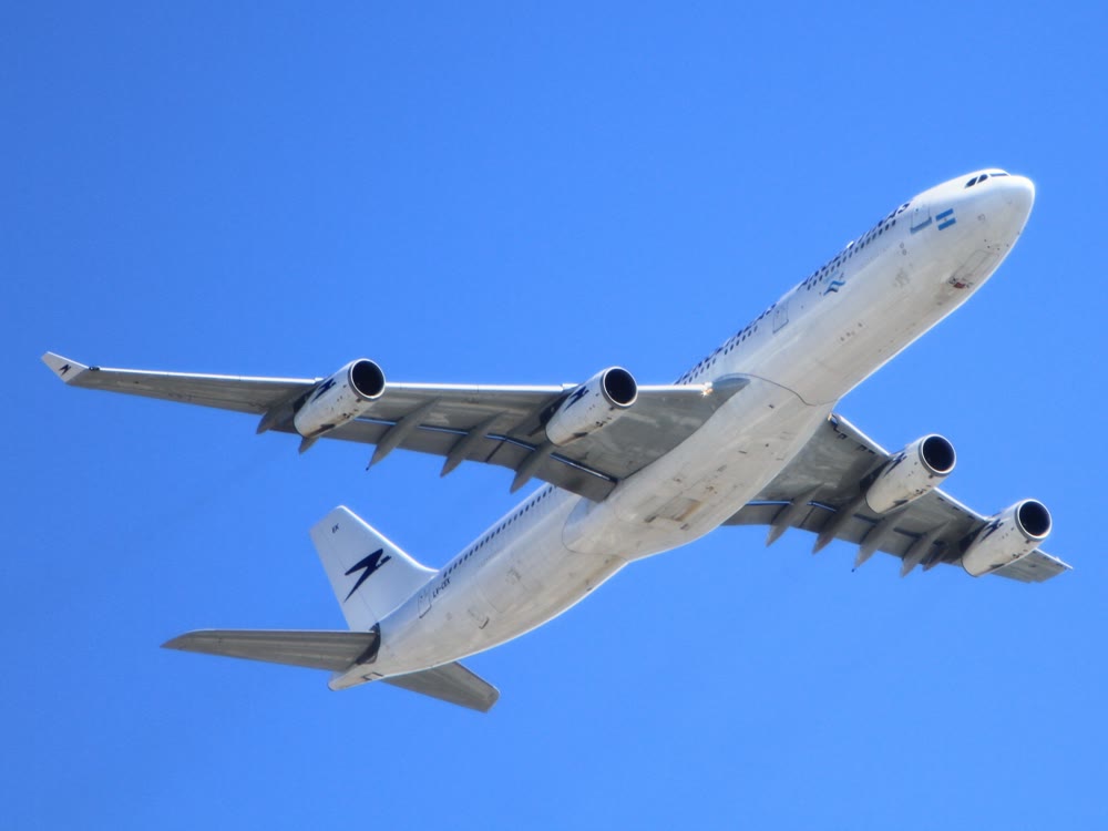 青空を上昇していく旅客機